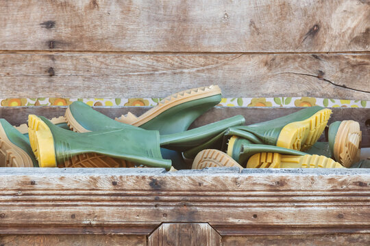 Wooden box filled with new green rubber rain boots