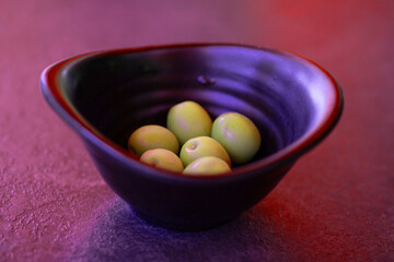 Green olives in a purple bowl