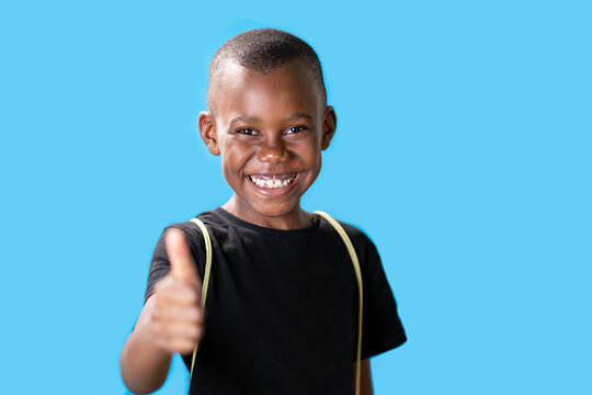 giovane ragazzo nero su sfondo blu con i pollici in su perché è successo qualcosa di buono