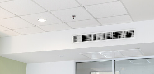Ceiling mounted cassette type air conditioner and modern lamp light on white ceiling. duct air conditioner for home or office
