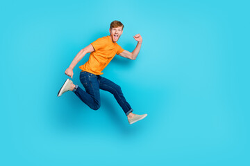 Fototapeta na wymiar Full length profile photo of impressed red hair guy jump wear t-shirt jeans boots isolated on blue color background