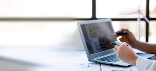 Two architects and engineers are in a meeting to discuss and inspect the house designs to meet the...