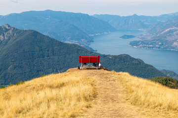 the big red bench placed on the mountain in a panoramic position