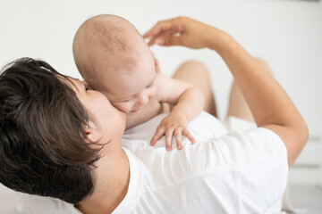 happy mother with baby on bed