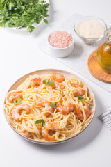 Italian pasta fettuccine or spaghetti in a creamy cheese sauce with shrimp or prawns on a plate