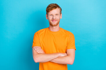 Photo of confident positive smiling guy with red hairstyle wear orange t-shirt standing folded arms...
