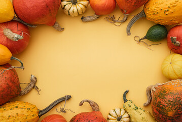 Thanksgiving day poster with squash and decorative gourds frame on yellow background