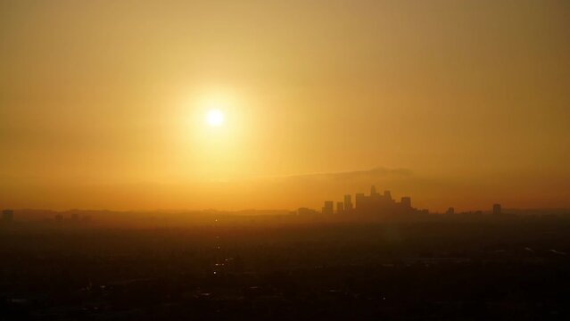 Aerial Lockdown Silhouette Of Buildings In Financial District By Mountains At Sunset - Los Angeles, California
