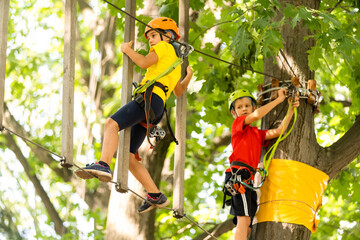 Cute children. Boy and girl climbing in a rope playground structure at adventure park