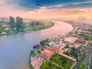 Naklejka premium Aerial view of Ho Chi Minh City skyline and skyscrapers on Saigon river, Nha Rong wharf and Bach Dang harbor. Colorful Saigon river at sunset. Travel concept.