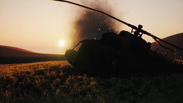 Silhouette of a burning military helicopter. Destroyed helicopter in the field