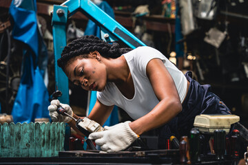 Obraz na płótnie Canvas Female mechanic checks parts of a car so that repairs can be restored.