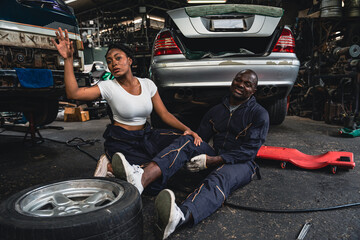 Male mechanic is sick while on duty female mechanic comes in to provide first aid.