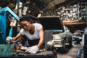 Female mechanic is repairing the parts of the car so that it can be used.