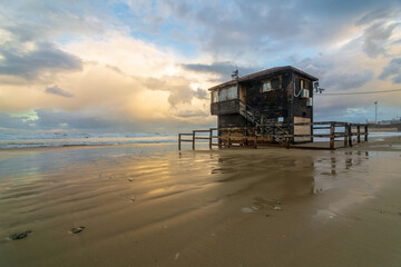Lifeguard tower during a colorful storm on the Medditeranian in ultra wide angle