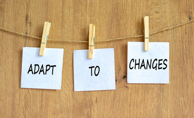 Adapt to changes and support symbol. Concept words Adapt to changes on white papers on wooden...