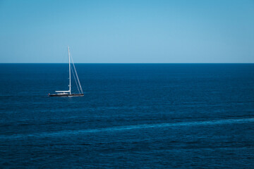Yacht in the blue sea background, small sailboat adventure, seascape, boat travel through on the deep ocean horizon.