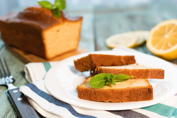 Lemon pound cake on rustic wooden background with lemon.