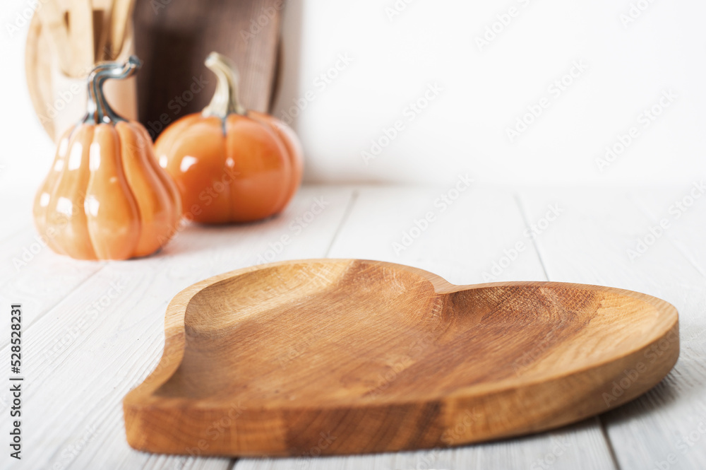 Wall mural wooden dish heart on light background. serving, cooking, recipes for autumn dishes. pumpkins in defo