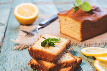 Lemon pound cake on rustic wooden background with lemon.