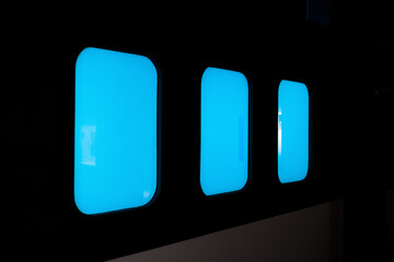 three blue windows on black wall