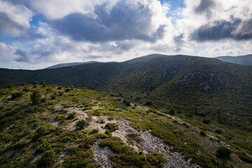 Naklejka premium Fotografía aérea de la cima de una montaña de la sierra de Irta en Peñíscola con el cielo nublado al fondo.