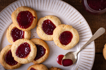 Argentinian traditional cookies called Pepas filled with jam placed on white plate and old wooden...