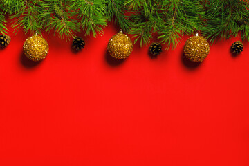 Christmas New Year banner from fir branches with cones, balls on a red background