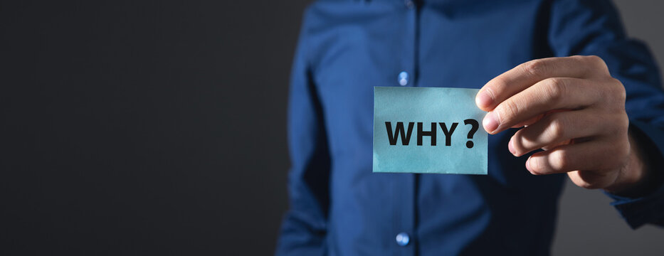 Man showing Why? word on sticky note.