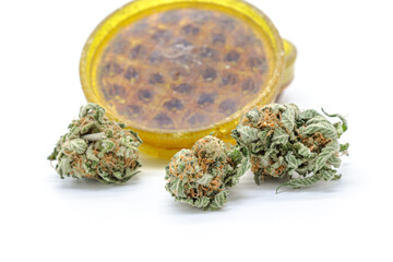 marijuana bud grinder and dried weed isolated on a white background