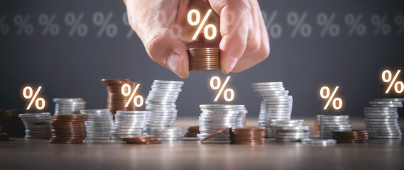 Male hand showing Percentage symbols and coins. Interest rates