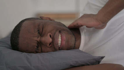 Fototapeta na wymiar Close up of African Man having Neck Pain while Sleeping in Bed