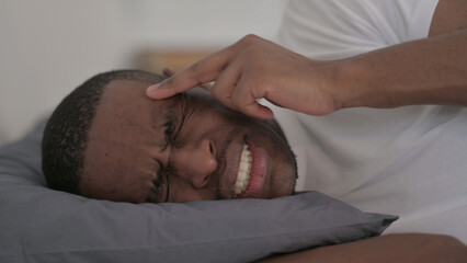 Fototapeta na wymiar Close up of African Man having Headache while Sleeping in Bed