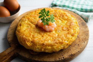 Garlic prawn omelette. Spanish traditional tapas. Recipe with potatoes, egg and prawns.