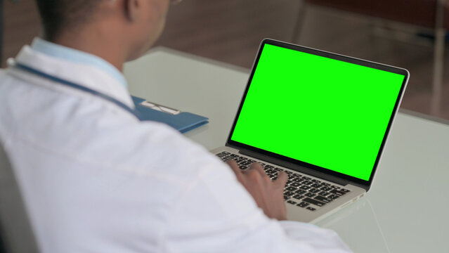 Young African Doctor Using Laptop with Green Screen - Powered by Adobe