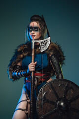 Photo of nordic huntress woman with strup back longbow holding shield and axe.