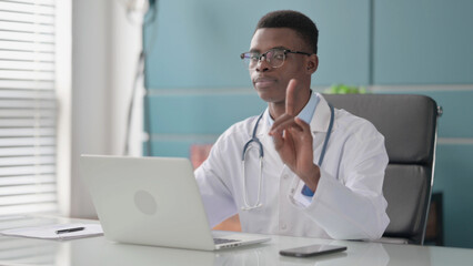 Young African Doctor Shaking Head as No Sign while using Laptop in Office