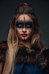 Portrait of nordic antique huntress dressed in attire and fur coat looking at camera.