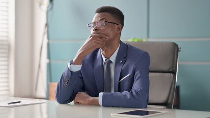 Pensive Young African Businessman Thinking While Sitting in Office