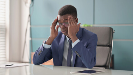 Young African Businessman with Headache Sitting in Office