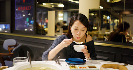 Woman having her hot soup at chinese restaurant