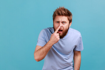 You are liar. Portrait of shocked bearded man standing, touching his nose and showing lie gesture,...