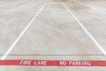 Fire lane no parking marking on the road of a parking lot, red line with white inscription on the...