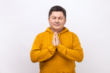 Yoga time. Portrait of middle aged handsome calm man standing in yoga pose and try to relaxing,...