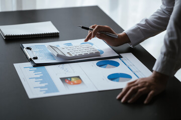 Close up of business hands working and calculating on financial and accounting graft and chart in...