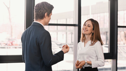 employer gesturing while talking to happy woman on job interview.