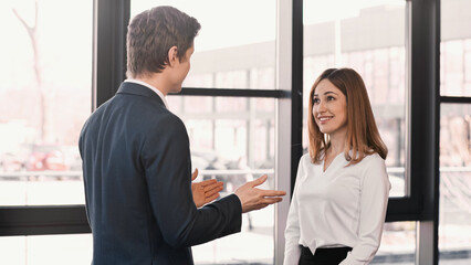 businessman pointing with hands at happy woman during job interview.