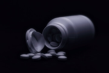 Tabletten - Medikamente - White medical pills or tablets with bottle on black background. - with...