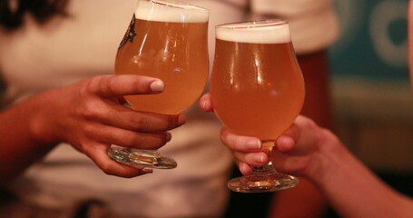 clinking two draft beers, female hands