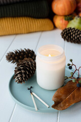 High angle view autumn composition with sweaters and candles, white candle mockup design